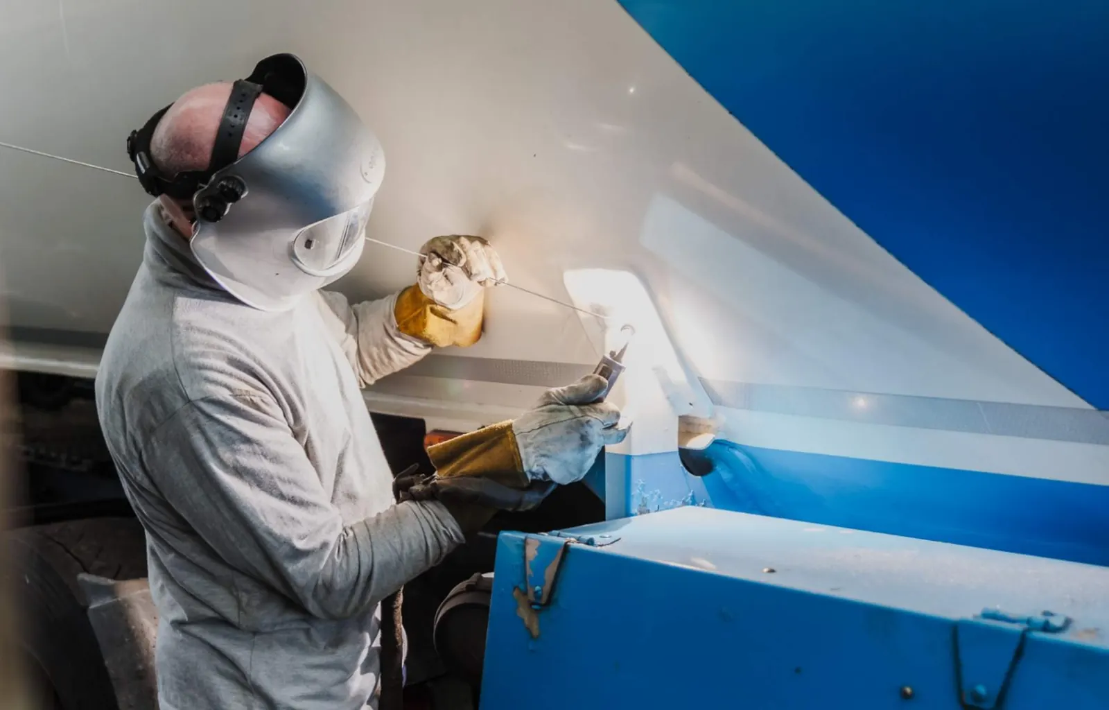 Mitarbeiter der NWR GmbH bearbeitet in Schutzkleidung einen Tankaufbau