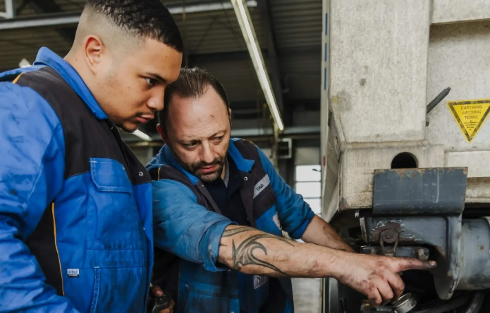 Zwei Mechaniker der NWR GmbH arbeiten gemeinsam an einem Nutzfahrzeug