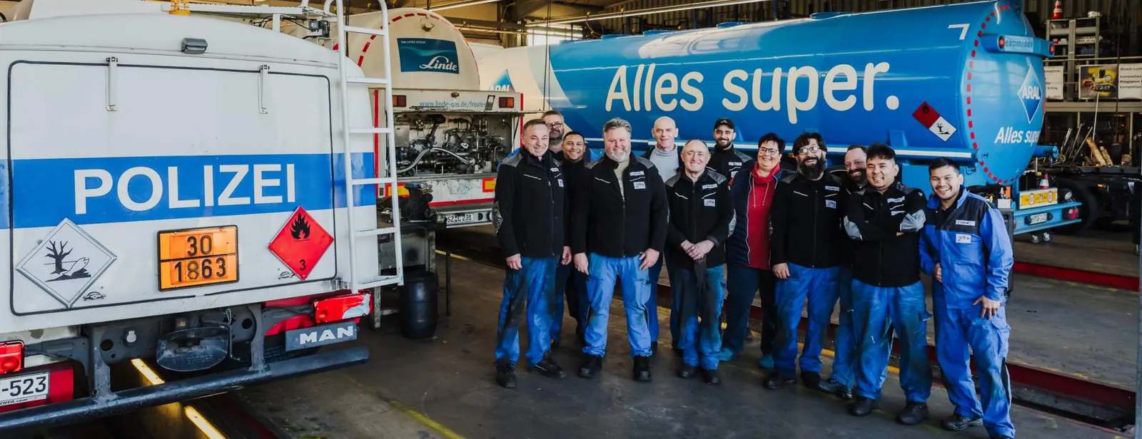 Das Team der NWR GmbH vor einem Tankfahrzeug in der Werkstatt
