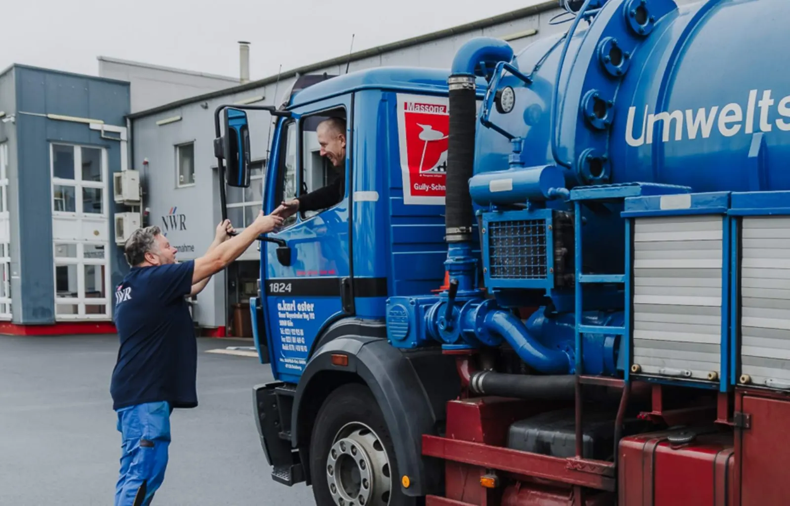 Mitarbeiter der NWR GmbH bei der Übergabe eines Nutzfahrzeugs vor der Werkstatt
